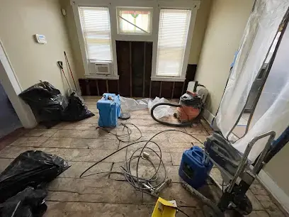 Air movers and a dehumidifier drying a lower level room after water damage in Roselle, NJ