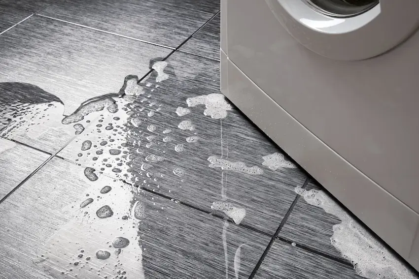 Water spreading across a tile floor beside a leaking washing machine in a Union, NJ home